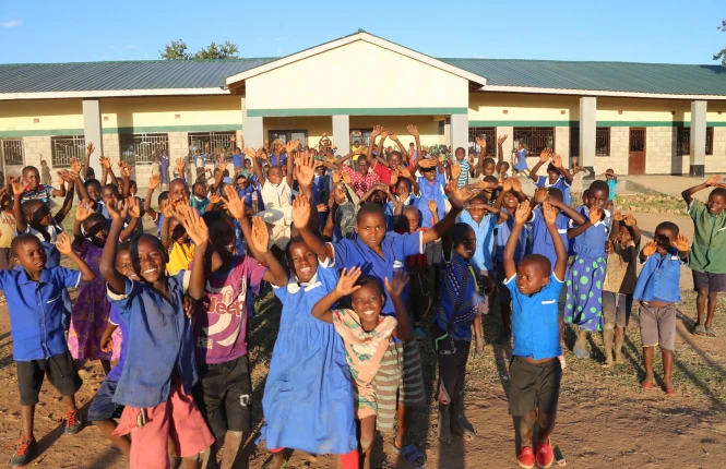 A group of student celebrating outside their new school